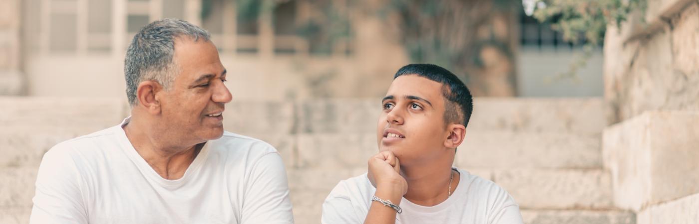 father talking to son on porch