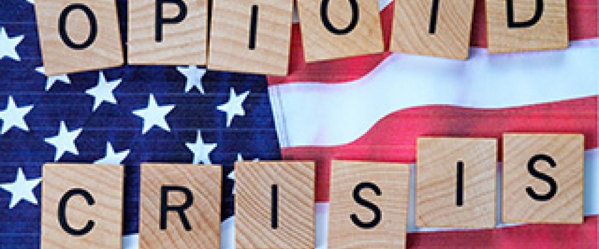 scrabble tiles spelling 'opioid crisis' over usa flag background