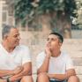 father talking to son on porch