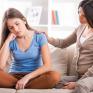 Daughter and mother talk on the sofa