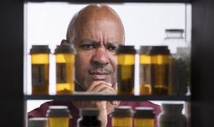 man looking in to medicine cabinet
