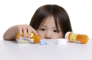 child opening prescription medicine bottle